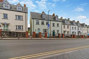 una fila de casas blancas al lado de una calle en Hafan - Saundersfoot, en Saundersfoot