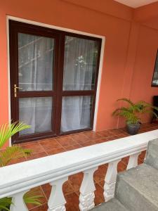 un porche avec une fenêtre et deux plantes dans l'établissement Spacious Beach house, à Buccament