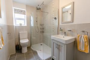 Un baño con inodoro, lavabo y ducha. en Trenoweth Sea View, en Saint Keverne 16 fotos más