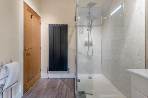 a bathroom with a shower with a glass door at Isel Gate Cottage in Sunderland +14 photos