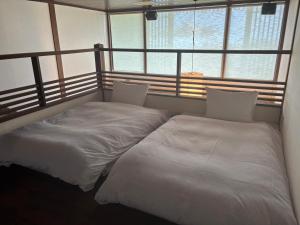 two beds sitting next to each other in a room at 大同ガーデンホテル湯の山リゾート in Wada