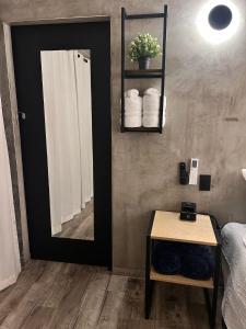 ein Bad mit einem Spiegel, einem Tisch und einem Bett in der Unterkunft Departamento Moderno con balcón y piscina climatizada in Rosarito Beach