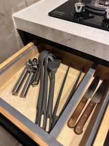 eine Schublade mit Messern und anderen Küchenutensilien in der Unterkunft Departamento Moderno con balcón y piscina climatizada in Rosarito Beach