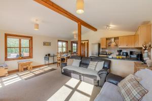 a living room with a couch and a kitchen at Kendo Retreat- Herrington Park in Elvington