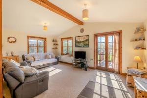 a living room with a couch and a tv at Kendo Retreat- Herrington Park in Elvington