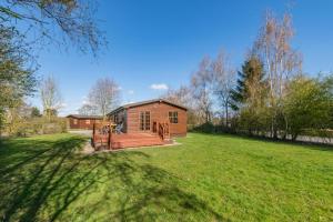 a wooden cabin in a field with a yard at Kendo Retreat- Herrington Park in Elvington