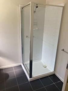 una doccia con una porta in vetro in un bagno di The Blue House a Venus Bay