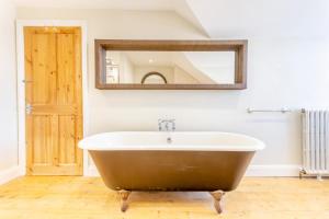 a bath tub in a bathroom with a mirror at Sea Vista - Dovercourt in Harwich +34 photos