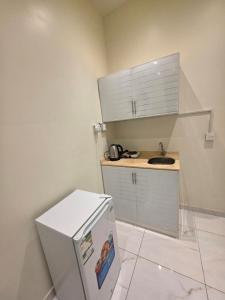 a small kitchen with a white refrigerator and a sink at شقق ضيافة خاصة in Abha +22 photos