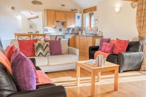 ein Wohnzimmer mit zwei Sofas und einem Tisch in der Unterkunft Damson Cottage - Waberthwaite in Waberthwaite + 21 Fotos