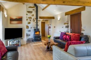 ein Wohnzimmer mit Couch und Kamin in der Unterkunft Damson Cottage - Waberthwaite in Waberthwaite