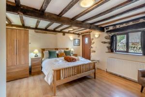 ein Schlafzimmer mit einem Bett, auf dem ein Hund liegt in der Unterkunft Damson Cottage - Waberthwaite in Waberthwaite