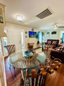 a living room with a glass table and chairs at Family Cottage 1 mile to Carolina Beach in Wilmington