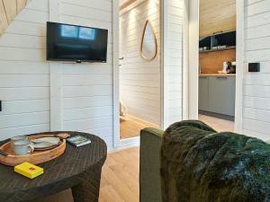 a living room with a table and a tv in a house at Elm - Pantygelli Escapes in Abergavenny