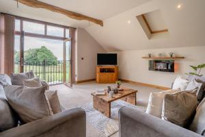 a living room with a couch and a table at Coed Y Nant Barn in Cilybebyll