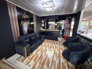 Una sala de estar con muebles negros y un bar. en Hotel San Francisco Real Villa Garzón Putumayo, en Villagarzón