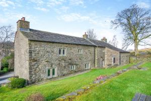 une ancienne maison en pierre avec une cour verdoyante dans l'établissement Southwaite Cottage, à Outhgill