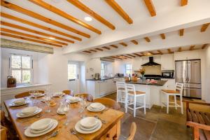 une cuisine et une salle à manger avec une table et des chaises en bois dans l'établissement Southwaite Cottage, à Outhgill