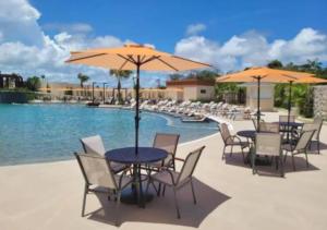 a table and chairs with umbrellas next to a pool at Aqualand resort in Ilha de Atalaia