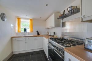 a kitchen with white cabinets and a stove top oven at Belvedere in New Quay