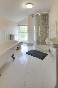 a bathroom with two sinks and a tub and a shower at Belvedere in New Quay +10 photos