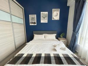 a bedroom with a large bed with blue walls at Ipoh The Majestic Comfortable Homestay SY29 in Ipoh +19 photos