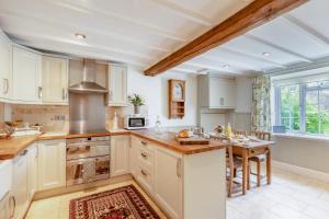 a large kitchen with white cabinets and a table at Bonnings Cottage in Barrington