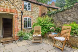 two chairs and a table in front of a house at Bonnings Cottage in Barrington +20 photos