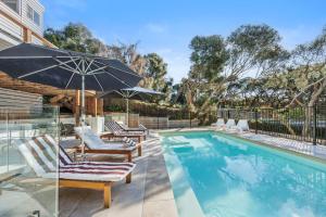 een zwembad met ligstoelen en een parasol bij A Vue De Rye in Rye
