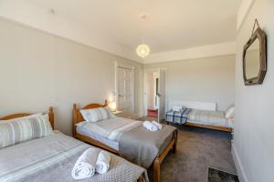 Un dormitorio con dos camas y un espejo. en Llansantffraed House, en Hundred House
