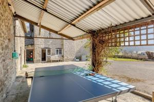 una mesa de ping pong dentro de un edificio en Llansantffraed House, en Hundred House