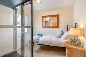 a bedroom with a bed and a mirror at Mays Place in Tenby