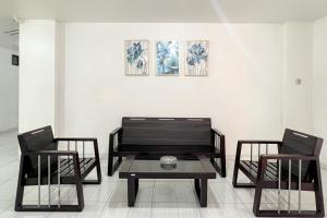 a living room with two chairs and a table at RedDoorz at Vall Guest House Balikpapan in Balikpapan