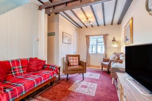 un salon avec des canapés et une télévision à écran plat dans l'établissement The Olde Cottage - Hythe, à Hythe