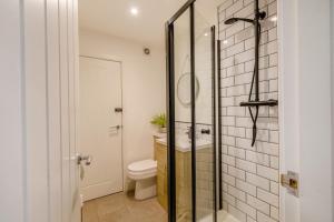 a bathroom with a toilet and a glass shower door at 23 Coastal Comfort in Haverigg