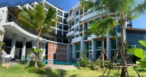 奈扬海滩Atom Phuket Hotel的享有棕榈树建筑的外部景色