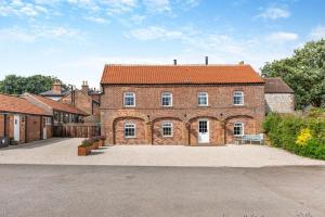 a large brick building with a red roof at Willerby Grange Farm in Willerby