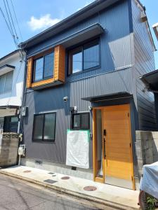 une maison avec une porte marron dans une rue dans l'établissement Kamogawa Sanpo, à Shimmachidōri
