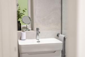 a bathroom with a white sink and a mirror at Darnley Lodge in Cobham +11 photos