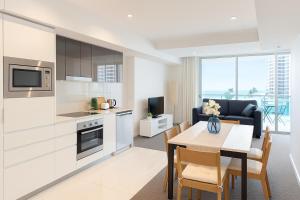 Entire 2 bdrm apt in Hilton Surfers Paradise -7 في غولد كوست: مطبخ وغرفة معيشة مع طاولة وغرفة طعام