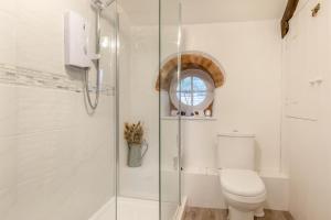 a bathroom with a toilet and a glass shower at Lane Cottage in Dulverton