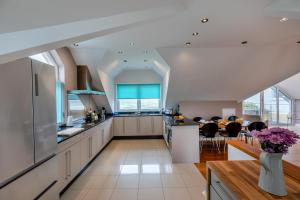 cocina con armarios blancos y comedor en Ocean Villa, en Woolacombe