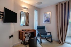 una habitación con un escritorio y una silla y un televisor en Ocean Villa, en Woolacombe