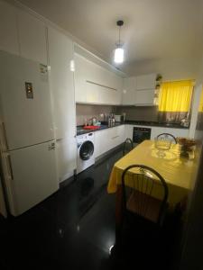 cocina con mesa y mantel amarillo en Cozy Apartment, 3 Bedrooms, en Praia