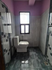 a bathroom with a toilet and a window at Room in Kapan, Near Boudhanath Stupa in Kathmandu