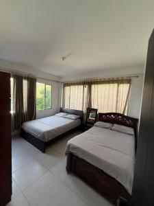 a bedroom with two beds and a window at Amanecer Entre Montañas in Las Granjas