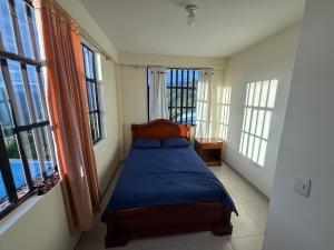 a bedroom with a bed in a room with windows at Amanecer Entre Montañas in Las Granjas