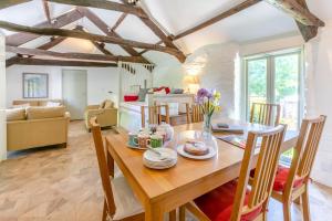 a dining room and living room with a table and chairs at The Lambs Barn in Lewannick