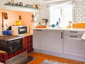 a kitchen with white cabinets and a microwave at 4 person holiday home in Rönnäng in Rönnäng +19 photos