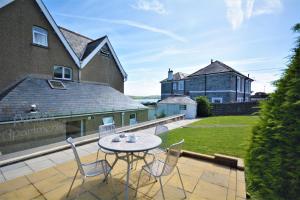 a patio with a table and chairs and a house at 4 Pentyre House in Padstow +7 photos